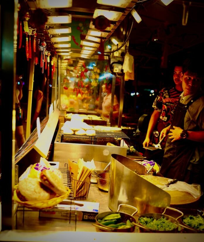 Street food vendor preparing food at night.
