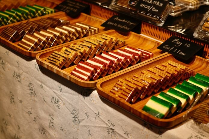 Rows of colorful layered cakes on wooden trays.